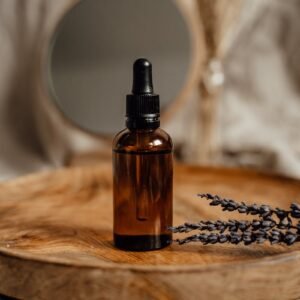 Amber glass dropper bottle on a wooden tray with lavender, ideal for skincare presentations.